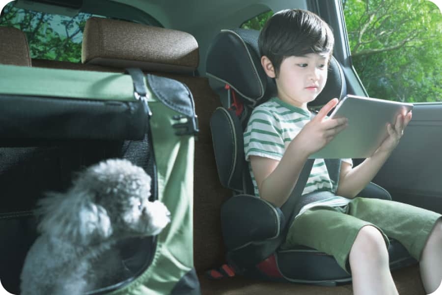 シエンタの車内でタブレットを観る子供と見つめる子犬